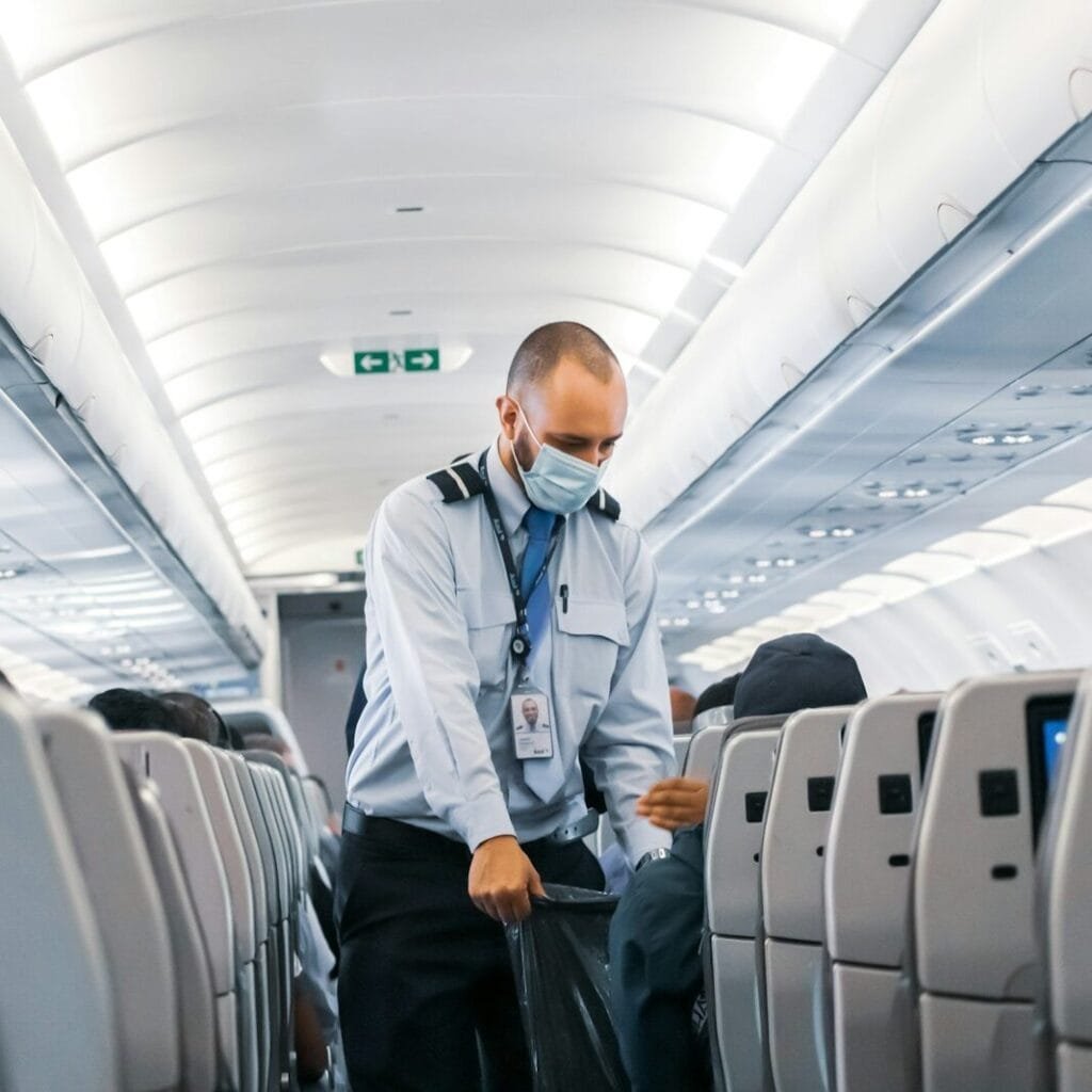 man in blue dress shirt standing in airplane